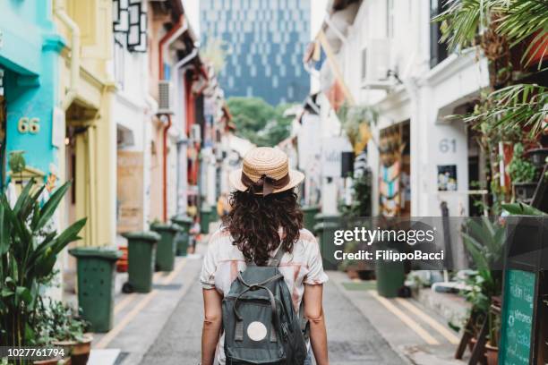 young adult woman exploring haji lane street in singapore - singapore tourist stock pictures, royalty-free photos & images