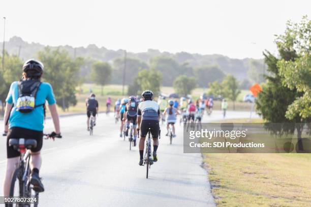 group of bike race for charity participants riding - sports race bicycle stock pictures, royalty-free photos & images