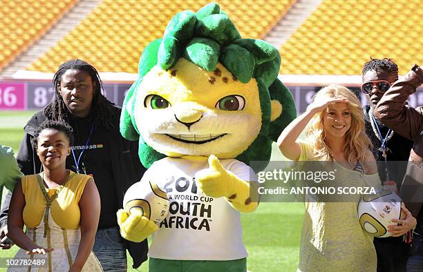 Colombia's singer Shakira, holding the Jo'bulani football that will be used for the final of the tournament and flanked by its mascot Zakumi, poses...