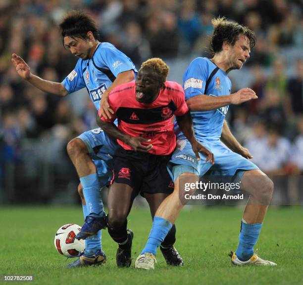 Louis Saha of Everton is sandwiched between two Sydney FC players during a pre-season friendly match between Sydney FC and Everton FC at ANZ Stadium...