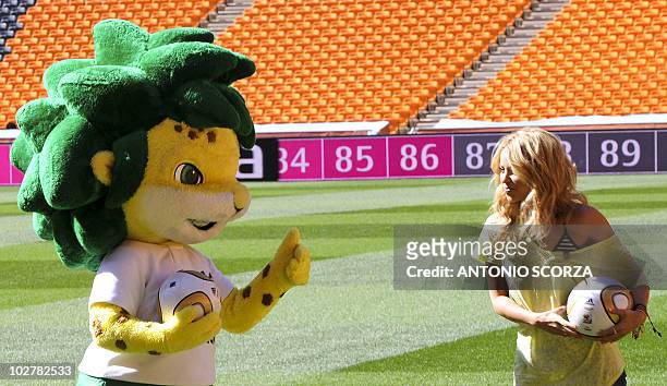 Colombia's singer Shakira, holding the Jo'bulani football that will be used for the final of the tournament, stands next the official mascot Zakumi...