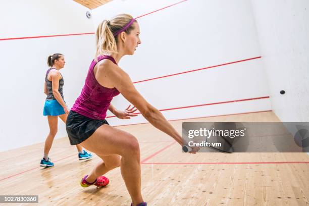 rückansicht eines weiblichen squash-spieler den ball - squash racquet stock-fotos und bilder