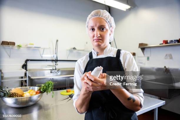 一位女廚師在準��備食物時無意中把手指伸進了商業廚房。 - cut on finger 個照片及圖片檔