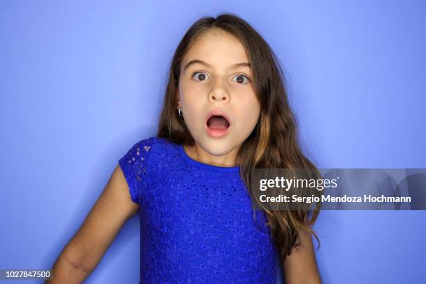 young girl looking at the camera surprised - surprise face kid stock-fotos und bilder