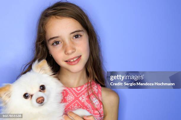 young girl looking at the camera with a white dog - tiny mexican girl stock-fotos und bilder