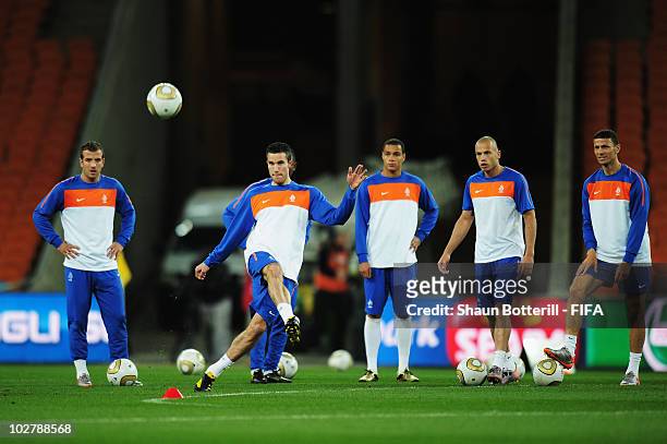 Robin Van Persie of the Netherlands passes the ball as team mates Rafael Van der Vaart, Gregory Van Der Wiel, Johnny Heitinga and Khalid Boulahrouz...