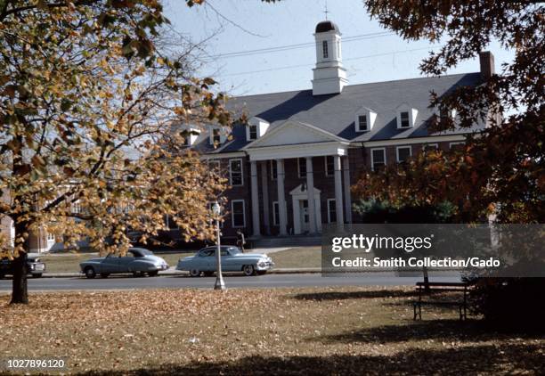 Cars parked in front of a building at Asbury University, a Christian liberal arts university in Wilmore, Kentucky, 1955.