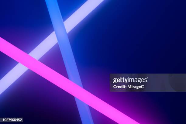 colorful glow sticks crossing - fluorescente - fotografias e filmes do acervo