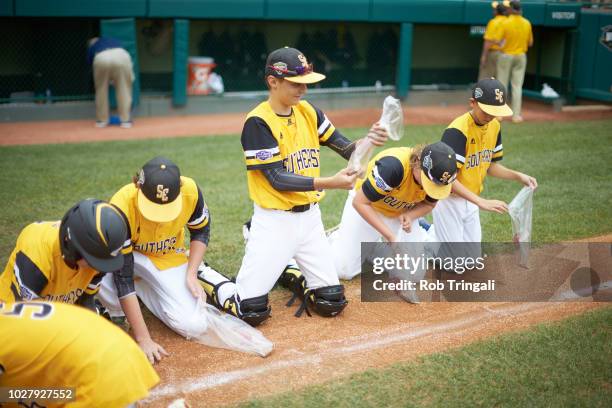 Little League World Series Championship: United States Southeast Region team collecting dirt from field as souvenirs after Championship game at...