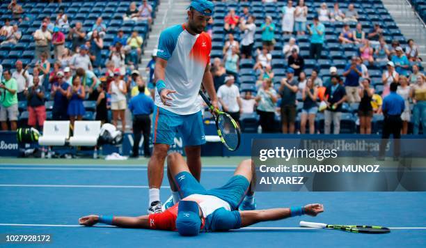 Juan Sebastian Cabal helps up teammate and Robert Farah, both of Colombia, after they lost to Mike Bryan and Jack Sock both of the US during their...