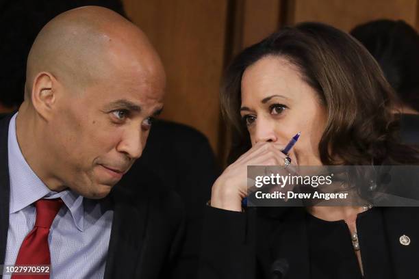 Sen. Cory Booker and Sen. Kamala Harris talk with each other as they listen to Supreme Court nominee Judge Brett Kavanaugh testify before the Senate...