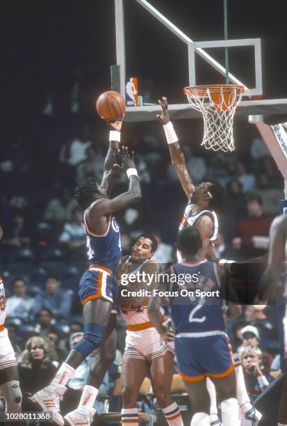 Michael Cage of the Los Angeles Clippers goes in for a layup over Cliff Robinson of the Washington Bullets during an NBA basketball game circa 1986...