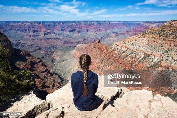 junge frau mit blick auf grand canyon im meditativen zustand - grand canyon stock-fotos und bilder