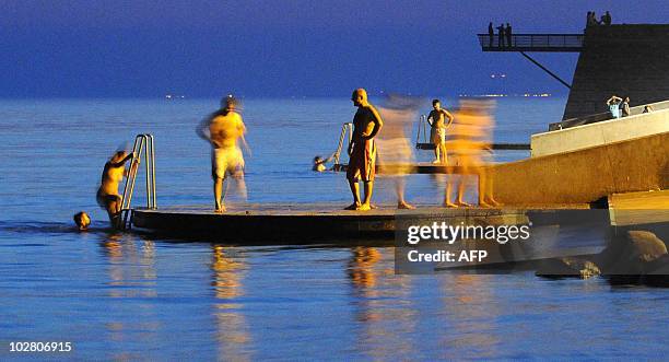 People get out of the water after a swim in the sea at the docks of Malmo late on July 10, 2010. AFP PHOTO / SCANPIX SWEDEN / JOHAN NILSSON