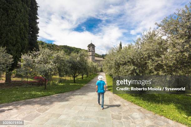 tourist walking to the old abbey, italy - cisterciense - fotografias e filmes do acervo