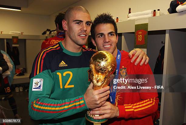 Victor Valdes and Cesc Fabregas of Spain pose with the trophy in the Spanish dressing room after they won the 2010 FIFA World Cup at Soccer City...