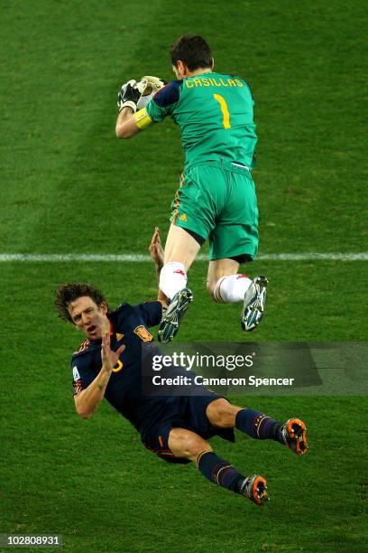 Iker Casillas of Spain catches the ball and falls into team mate Carles Puyol during the 2010 FIFA World Cup South Africa Final match between...