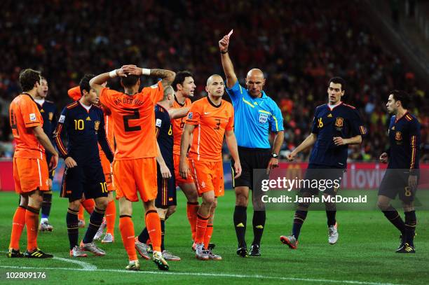 John Heitinga of the Netherlands is shown a second yellow card by referee Howard Webb and is sent off during the 2010 FIFA World Cup South Africa...