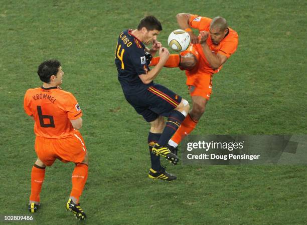 Nigel De Jong of the Netherlands tackles Xabi Alonso of Spain with a kick in the chest during the 2010 FIFA World Cup South Africa Final match...