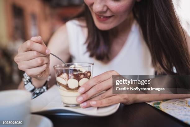 jonge vrouwen ontdekken van italië. jonge vrouwen genieten van koffie en tiramisu taart in verona-italië - tiramisu stockfoto's en -beelden