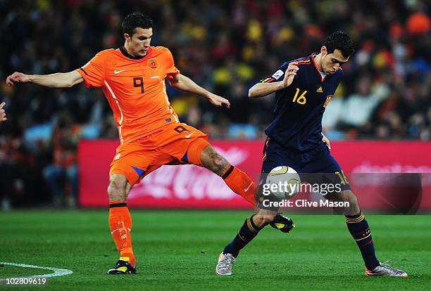 Robin Van Persie of the Netherlands tackles Sergio Busquets of Spain during the 2010 FIFA World Cup South Africa Final match between Netherlands and...