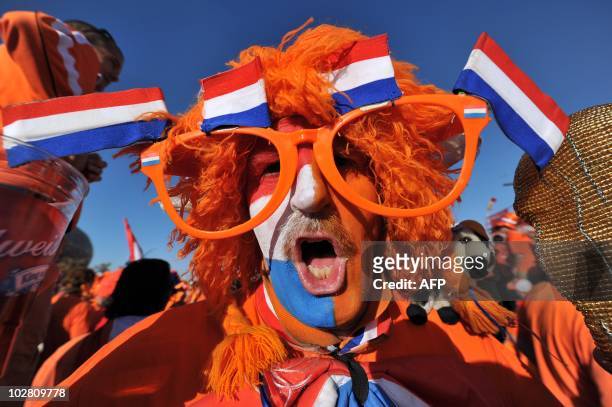Supporter of the Netherlands dressed in orange and wearing glasses poses outside Soccer City stadium in Soweto, in suburban Johannesburg ahead of the...