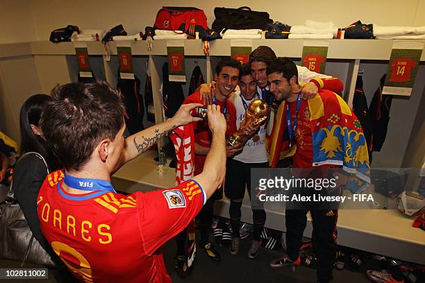Fernando Torres of Spain takes a photo of Alvaro Arbeloa, Jesus Navas, Sergio Ramos and Raul Albiol in the Spanish dressing room after they won the...