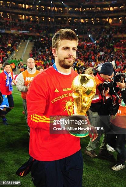 Gerard Pique of Spain celebrates with the World Cup during the 2010 FIFA World Cup South Africa Final match between Netherlands and Spain at Soccer...