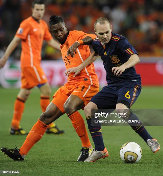 Spain's midfielder Andres Iniesta is challenged for the ball by Netherlands' striker Eljero Elia during extra-time in the 2010 World Cup football...