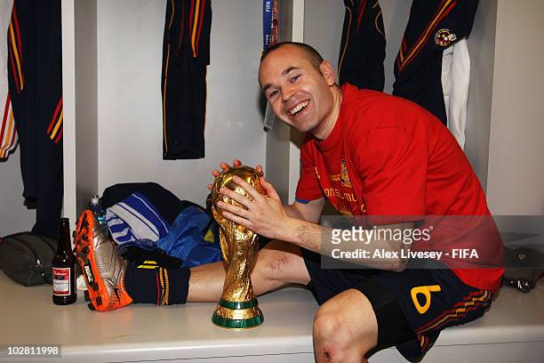 Andres Iniesta of Spain holds the trophy in the Spanish dressing room after they won the 2010 FIFA World Cup at Soccer City Stadium on July 11, 2010...