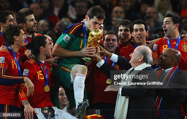 President Jospeph Sepp Blatter and South Africa President Jacob Zuma present the World Cup trophy to Iker Casillas, captain of Spain, following the...