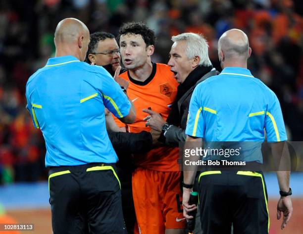 Netherlands coach Bert Van Marwijk together with player Mark Van Bommel make a point to referee Howard Webb after the 2010 FIFA World Cup Final...