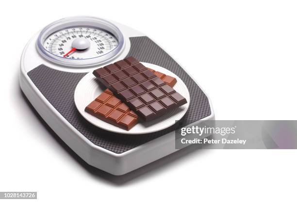 chocolate on bathroom scales - exceso fotografías e imágenes de stock