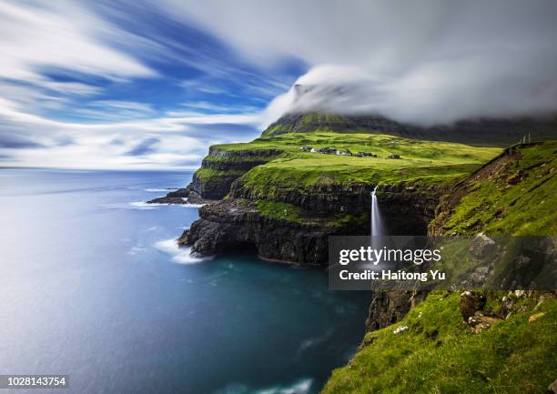 vagar, faroe islands. mulafossur waterfall. long exposure shot. - faroe islands stockfoto's en -beelden