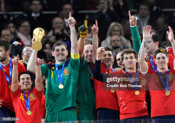 Goalkeeper and captain Iker Casillas of Spain lifts the trophy and celebrates with team-mates after the 2010 FIFA World Cup Final between the...