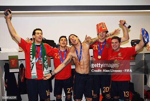 Sergio Busquets, Jesus Navas, Sergio Ramos, Javier Martinez and Juan Manuel Mata of Spain pose with the trophy in the Spanish dressing room after...