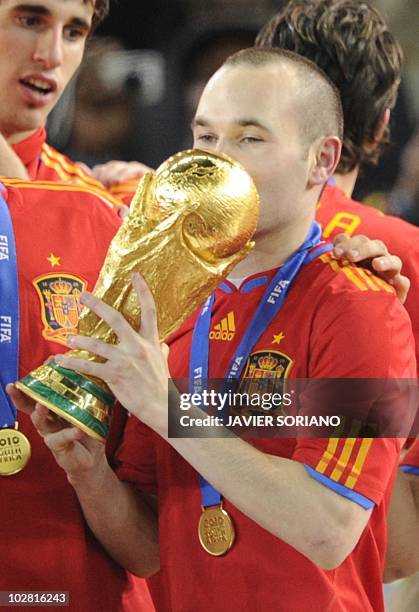 Spain's midfielder Andrés Iniesta kisses the trophy following the 2010 World Cup football final between the Netherlands and Spain on July 11, 2010 at...