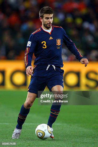 Gerard Pique of Spain runs with the ball during the 2010 FIFA World Cup South Africa Final match between Netherlands and Spain at Soccer City Stadium...