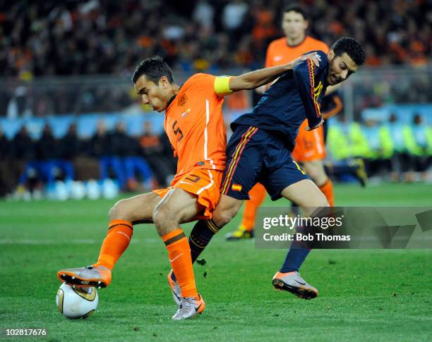 Giovanni Van Bronckhorst of the Netherlands tackled by Pedro of Spain during the 2010 FIFA World Cup Final between the Netherlands and Spain on July...