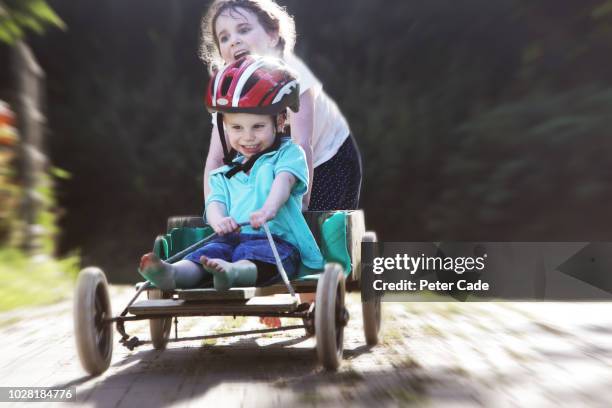 brother and sister playing on homemade go-kart - helmet cart stock pictures, royalty-free photos & images