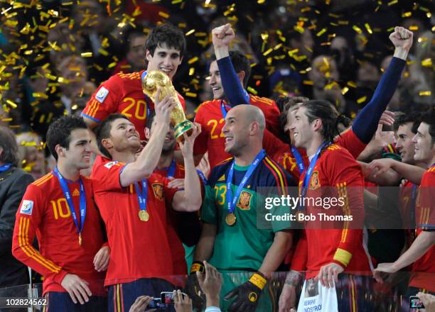 Xabi Alonso of Spain lifts the trophy and celebrates with team-mates after the 2010 FIFA World Cup Final between the Netherlands and Spain on July...