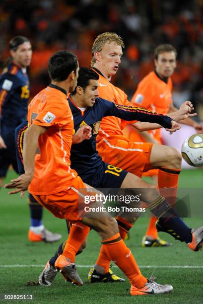 Pedro of Spain surrounded by Giovanni Van Bronckhorst and Dirk Kuyt of the Netherlands during the 2010 FIFA World Cup Final between the Netherlands...