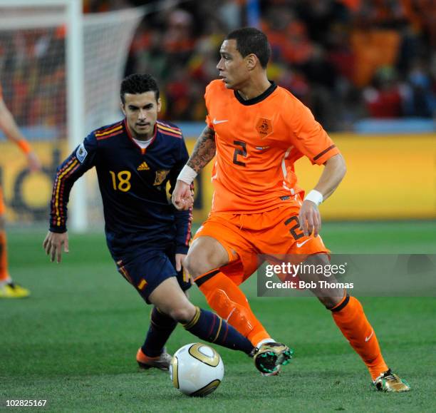 Gregory Van Der Wiel of the Netherlands watched by Pedro of Spain during the 2010 FIFA World Cup Final between the Netherlands and Spain on July 11,...