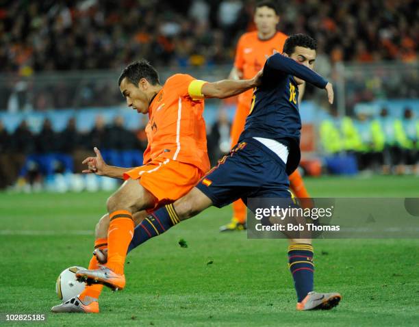 Giovanni Van Bronckhorst of the Netherlands tackled by Pedro of Spain during the 2010 FIFA World Cup Final between the Netherlands and Spain on July...