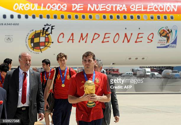 Spain's goalkeeper and captain Iker Casillas holds the trophy upon the team's arrival at Barajas' airport on July 12, 2010 in Madrid, a day after...