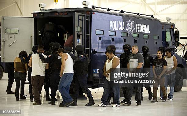 Nine alleged drug traffickers, members of the Sinaloa Cartel, are escorted to a police truck after being presented to the press in Mexico City, on...