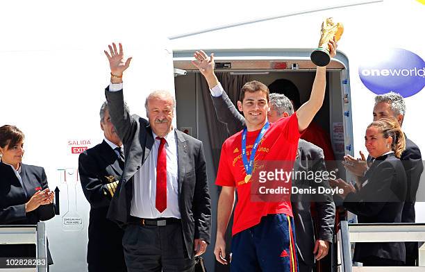 Spanish team captain Iker Casillas holds up the FIFA World Cup beside manager Vicente del Bosque at Barajas Airport on July 12, 2010 in Madrid, Spain.