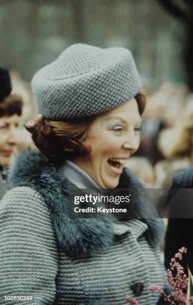 Crown Princess Beatrix of the Netherlands wearing a hat and fur stole while laughing, 1980.