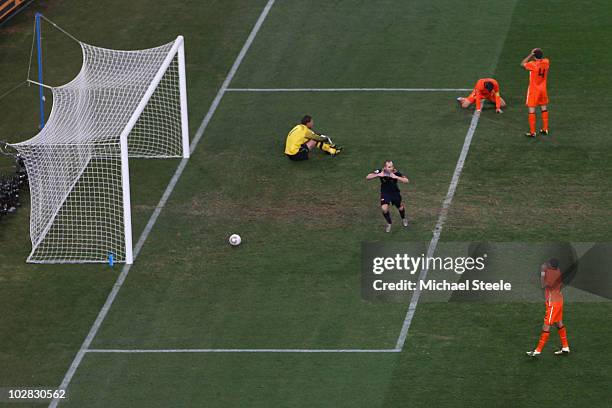 Andres Iniesta of Spain celebrates scoring the winning goal as Maarten Stekelenburg of the Netherlands sits dejected on the pitch during the 2010...