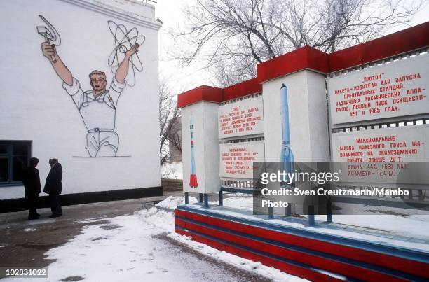 Baikonur inhabitants walk past propaganda signs that show images of Russia�s space history, on March 16 in Baikonur, Kazakhstan. Baikonur, located in...